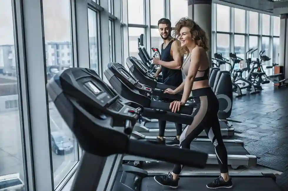 Couple de sportifs s'entraînant dans une salle de sport moderne équipée